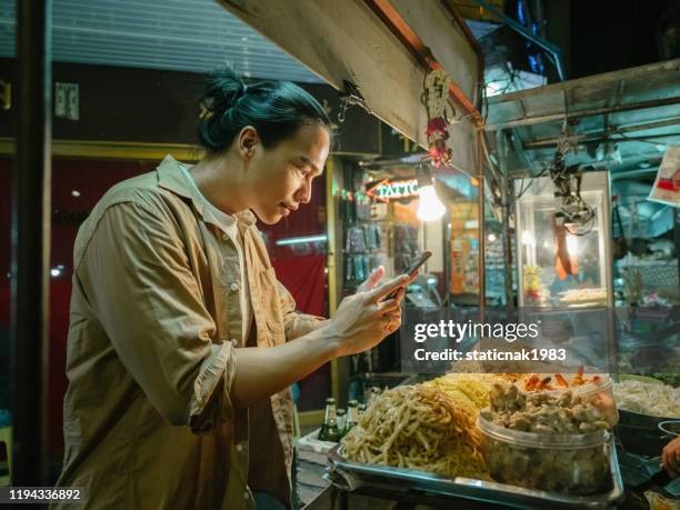 young man taking selfie with street food pad thai in khao san road. - khao san road stock pictures, royalty-free photos & images