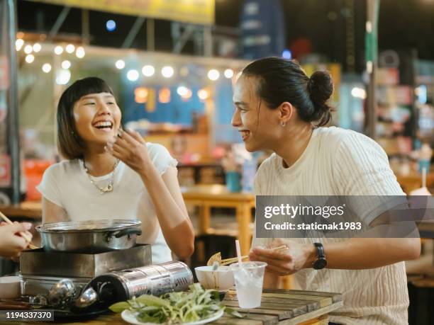 gelukkige aziatische jonge groep eten shabu shabu in het restaurant op de avondmarkt. - hot pots stockfoto's en -beelden