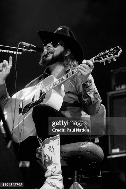 American Country musician Hank Williams Jr plays guitar as he performs onstage at an unspecified venue, Birmingham, Alabama, May 7, 1985.