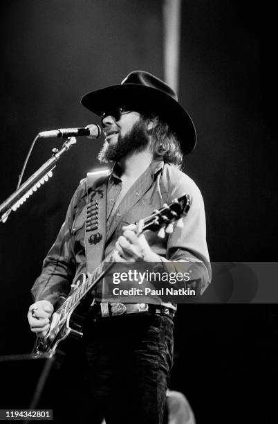 American Country musician Hank Williams Jr plays guitar as he performs onstage at an unspecified venue, Birmingham, Alabama, May 7, 1985.