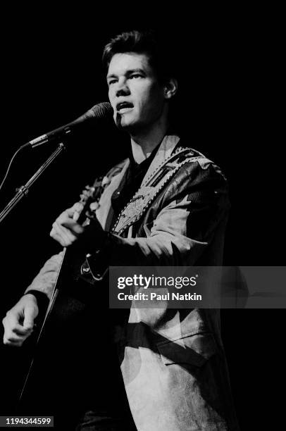 American Country musician Randy Travis plays guitar as he performs onstage at the Poplar Creek Music Theater, Hoffman Estates, Illinois, May 24,1987.