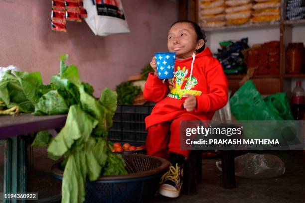 In this photograph taken on December 8 Khagendra Thapa Magar, the world's shortest man, looks on at a grocery shop in Pokhara, some 200 kms west of...