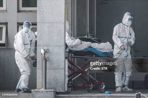 Medical staff members carry a patient into the Jinyintan hospital, where patients infected by a mysterious SARS-like virus are being treated, in...