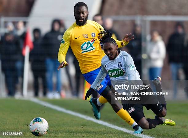 Epinal's midfielder Guy Tape vies with Saint-Pierroise's midfielder Ryan Ponti during the French Cup football match between Epinal and...