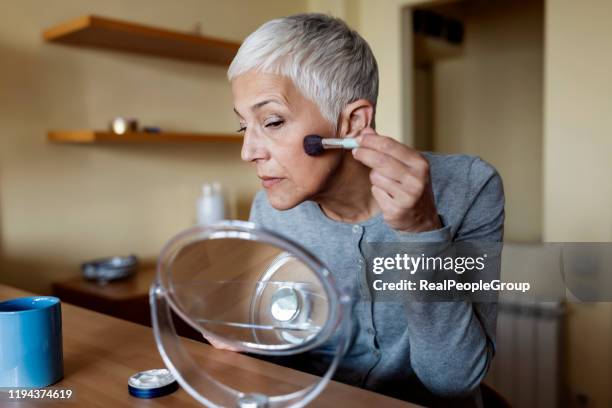 portrait of beautiful senior woman doing makeup. older beauty, aging gracefully concept - woman gray hair mirror stock pictures, royalty-free photos & images