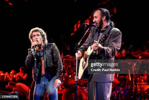 English Rock musicians Roger Daltry , on vocals, and Pete Townshend, on guitar, both of the group the Who, perform onstage at the Alpine Valley Music...