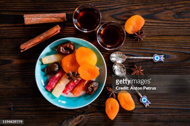 arabic tea in traditional glasses and sweets on on wooden background - delicia turca fotografías e imágenes de stock