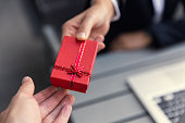 Business boss giving present gift box to office staff partner for job bonus concept.