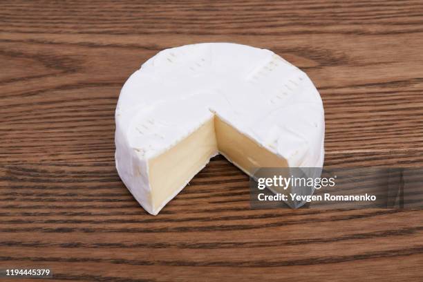 camembert cheese on a wooden background - camembert stock-fotos und bilder