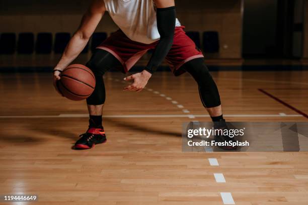 jugador de baloncesto regateando una pelota - bouncing fotografías e imágenes de stock