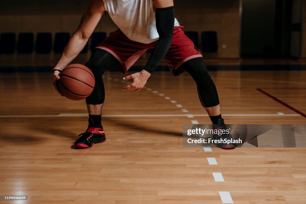 Jogador de basquetebol que dribla uma esfera
