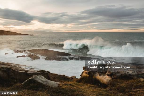big waves in the sea during sunset with cloudy sky - hondarribia stock-fotos und bilder