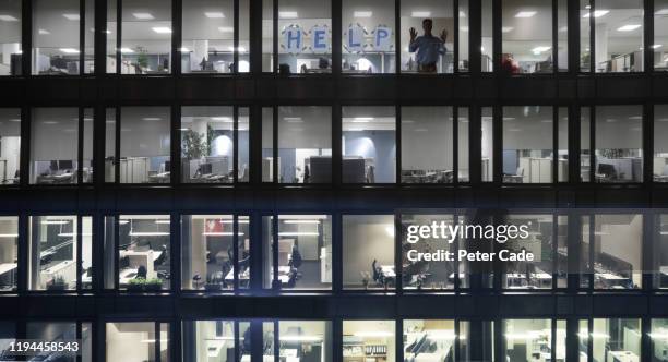 office block windows at night, man asking for help - empty office window stock pictures, royalty-free photos & images