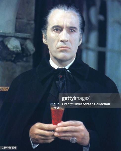 Christopher Lee, British actor, in costume and holding a glass of blood in a publicity portrait issued for the film, 'Taste the Blood of Dracula',...