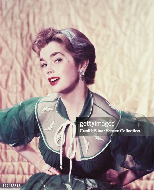 Dawn Addams, British actress, wearing a green-and-white dress in a studio portrait, circa 1955.