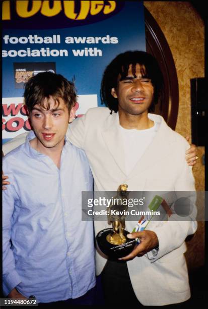 British singer-songwriter Damon Albarn of rock band Blur with Dutch soccer player Ruud Gullit, holding his award for "Best International Player in...