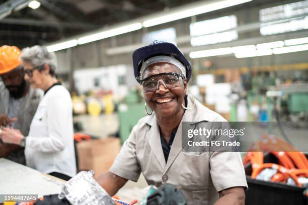 happy and dedicated senior employee working in a factory - work gender equality stock pictures, royalty-free photos & images