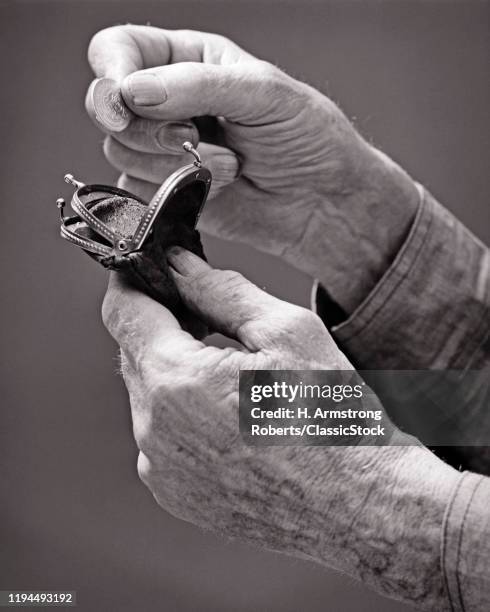 1940s HANDS OF AN ELDERLY MAN PUTTING A COIN INTO A CHANGE PURSE