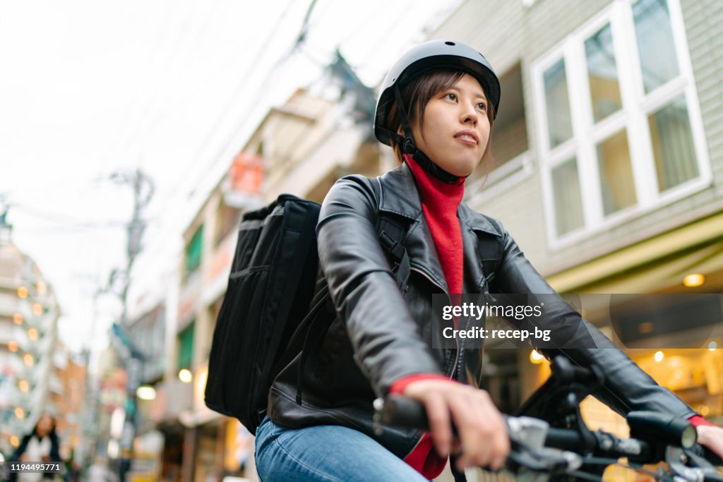 食べ物の配達のために自転車に乗っている若い女性