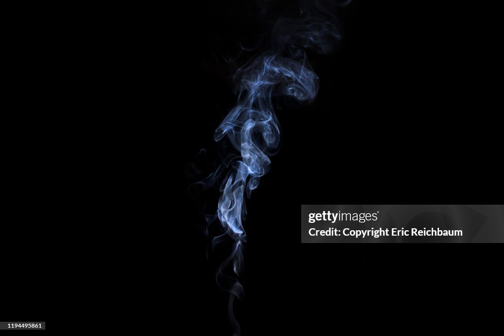 Whitee smoke billows up on a black background