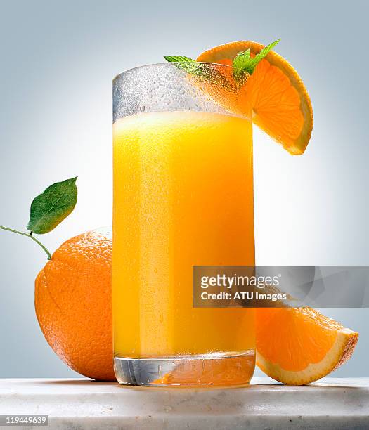 orange juice on marble ledge - orange juice stock-fotos und bilder