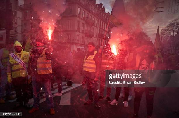 Members of the Sud Union light flares as they march through the streets of Paris in support of the National strike, with new unions joining the...