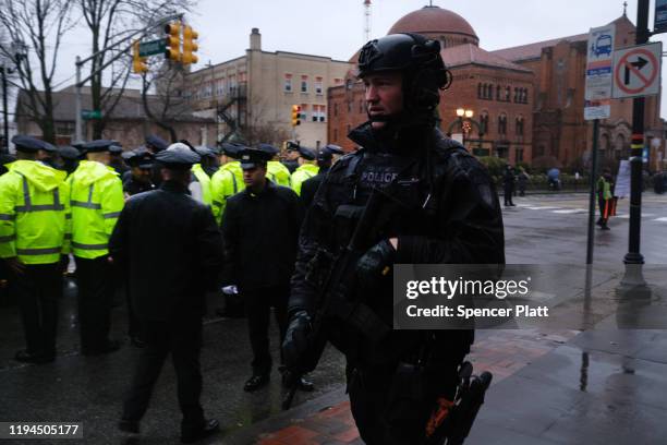 Police officers gather in the rain for the funeral service for New Jersey Detective Joseph Seals, who died last week in a shooting that left three...