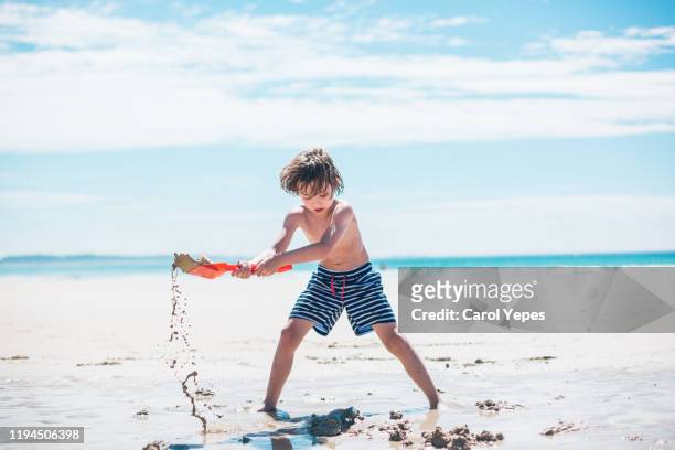 boy playing at the beach - digging hole stock pictures, royalty-free photos & images