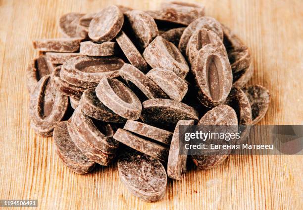 chocolate oval pistoles round bar sold by weight raw materials for couverture on wooden background close-up top view - chocolate flake bildbanksfoton och bilder