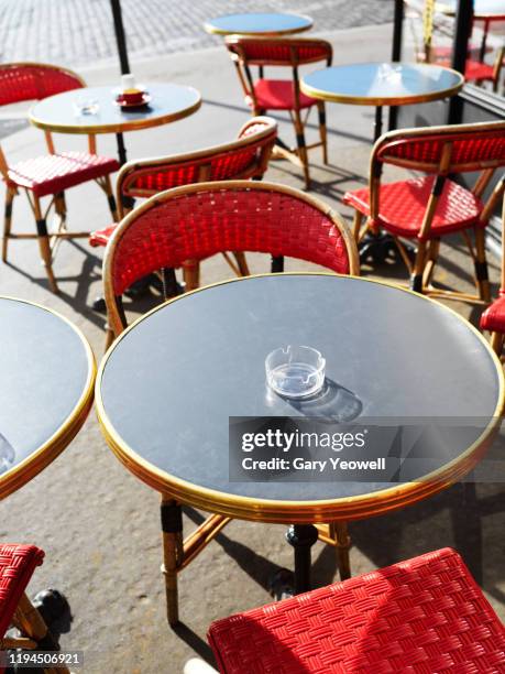 tables and chairs outside a cafe in paris - french cafe stock-fotos und bilder