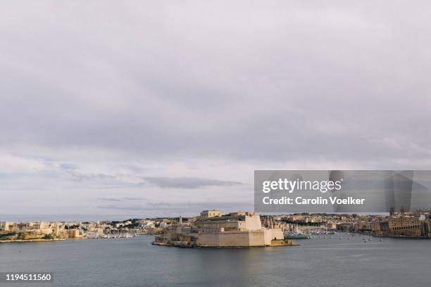 view from the upper barrakka gardens over fort st. angelo - malta harbour stock pictures, royalty-free photos & images