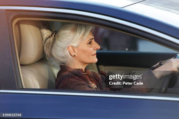 older lady in blue car - paardenstaart haar naar achteren stockfoto's en -beelden