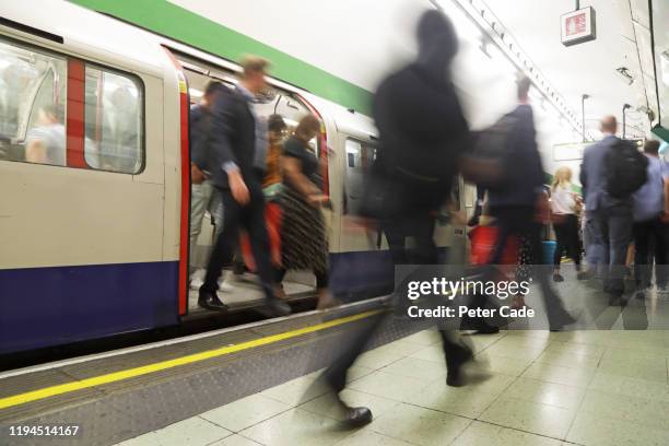 commuters at tube station - busy tube stock-fotos und bilder