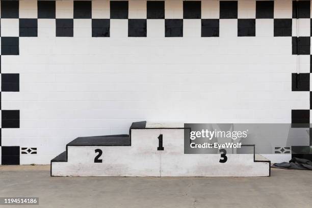 a beat up award podium at a race track - siegertreppe stock-fotos und bilder