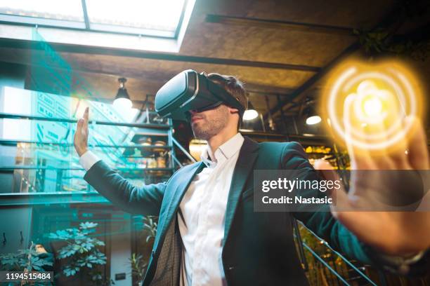 young businessman using virtual reality in a work space - yellow suit stock pictures, royalty-free photos & images