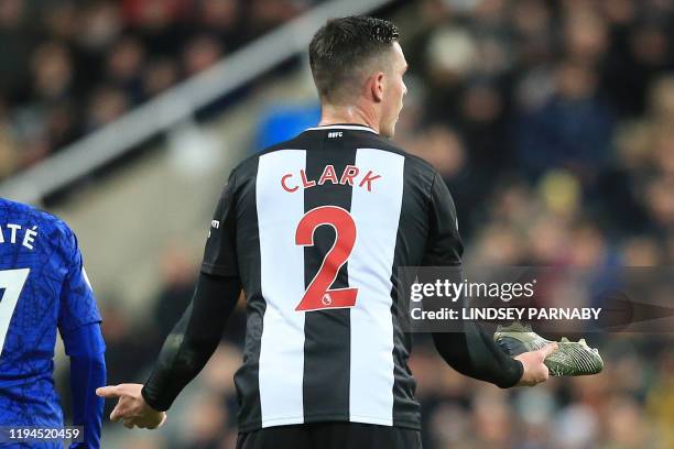 Newcastle United's Irish defender Ciaran Clark reacts after finding the football boot of teammate Newcastle United's Argentinian defender Federico...