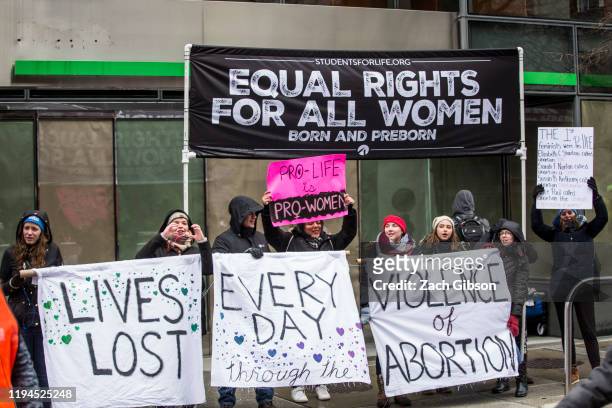 Anti-abortion demonstrators hold signs near the 2020 Women's March on January 18, 2020 in Washington, DC. Marches were held nationwide in cities...