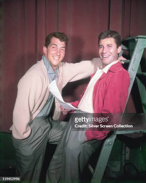 Dean Martin , US actor and singer, with Jerry Lewis, US actor and comedian, smiling in a studio portrait, with Lewis holding a script while leaning...