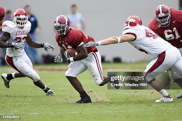 Alabama Crimson Tide running back Kenneth Darby avoids a tackle by Arkansas Razorback linebacker Clarke Moore during a 24 to 13 win over the...