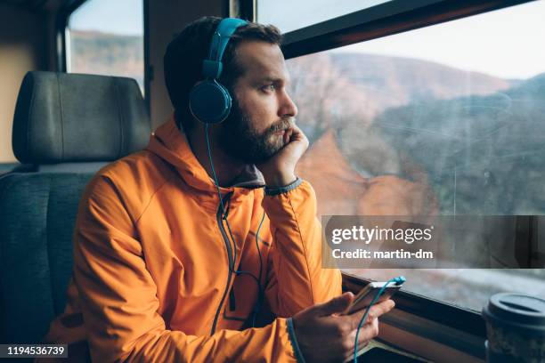 relaxed man in the train - millennial generation stock pictures, royalty-free photos & images