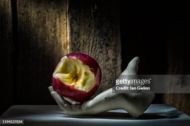apple in mannequin hand - schneewittchen stock-fotos und bilder