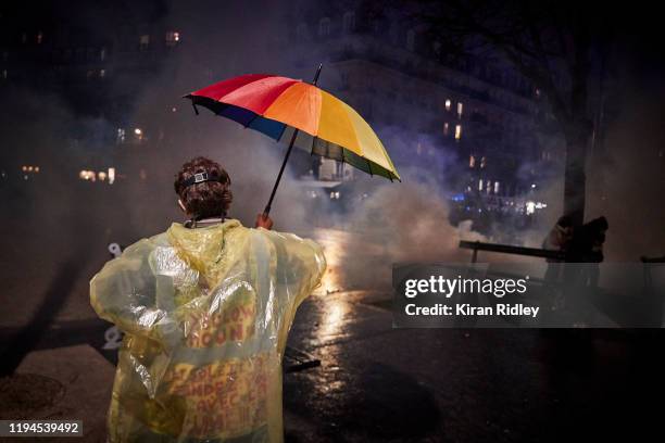 Protestor walks through clouds of tear gas at Place de la Nation as thousands take to the streets of Paris in support of the National Strike on a...