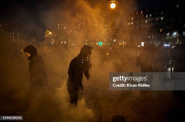Protestors walk through clouds of tear gas at Place de la Nation as thousands take to the streets of Paris in support of the National Strike on a...