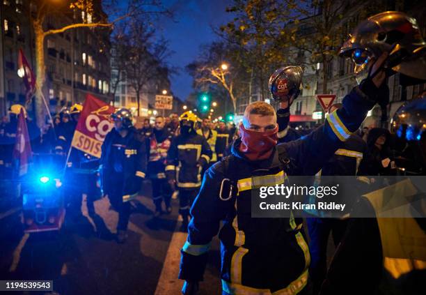 French fireman and members of the CGT union march through the streets of Paris chanting against President Macron as thousands take to the streets in...