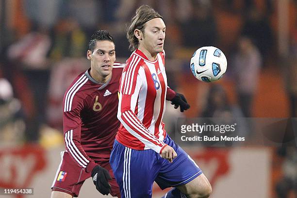 Edgar Barreto of Paraguay struggles for the ball with Gabriel Cichero of Venezuela during a match as part of Copa America 2011 Semifinal at Malvinas...