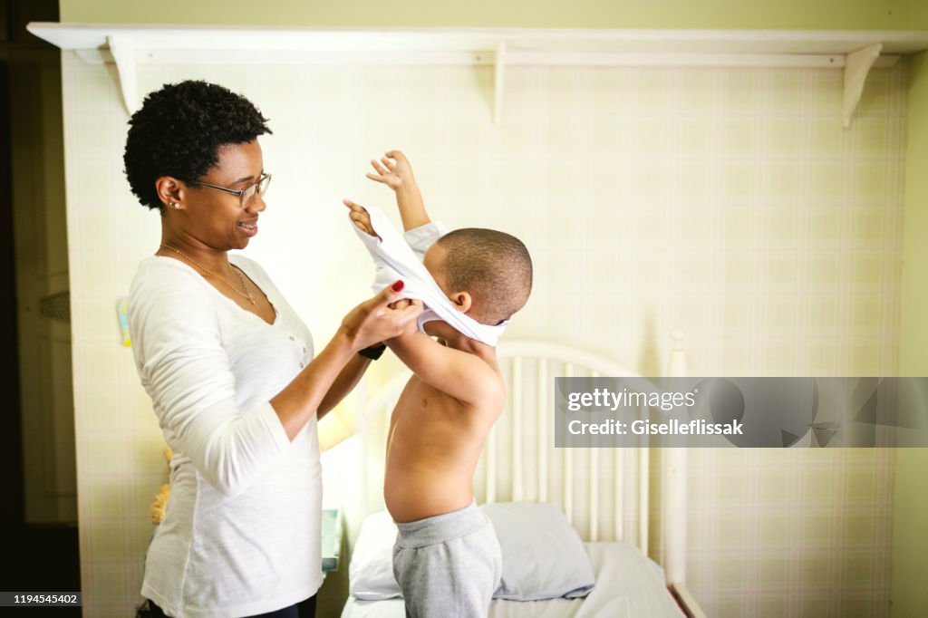 Mom Changing Clothes In Her Son In The Bedroom High-Res Stock
