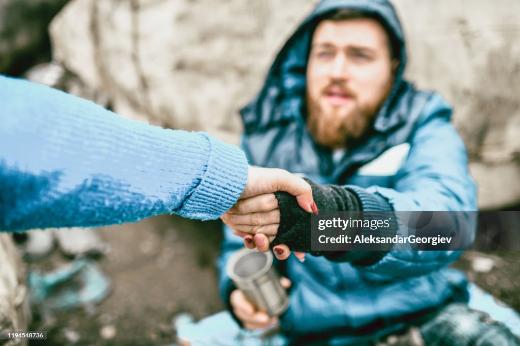 Homeless Male On The Street Getting Help From Female