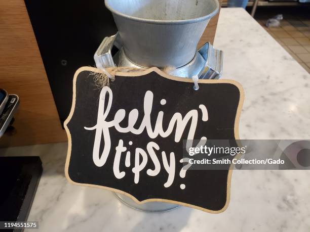 Close-up of comical tip jar with sign with pun reading Feelin Tipsy at Mendocino Farms restaurant in San Ramon, California, December 9, 2019.