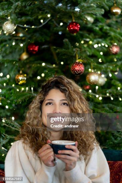 細心的女人在聖誕樹旁喝熱巧克力 - hot latina women 個照片及圖片檔
