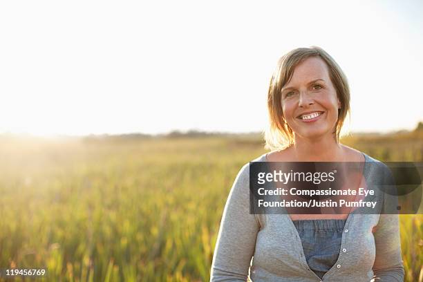 woman smiling in field - cef do not delete stock pictures, royalty-free photos & images